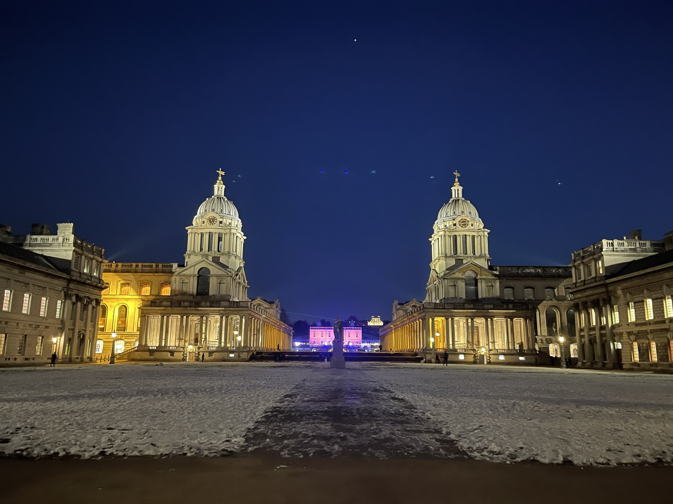 A grand historic institutional building in London, illuminated at night